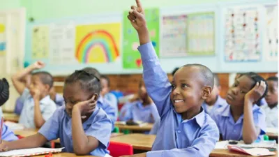 Élèves d'une école élémentaire de Dakar levant la main en classe